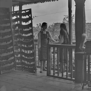 Veranda eines Wohnhauses in Bansko. Frauen in bulgarischer Tracht