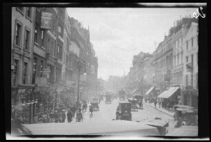London (England): Pferdekutschen und Passanten in einer großen Straße