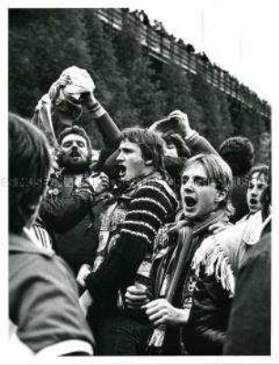 Singende, männliche Fußballfans (Altersgruppe 18-21)