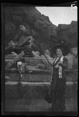 Hamburg: Dame ("nette Hamburgerin, mit der sich Eugen von Frauenholz gut vertrug") im "Tierpark von Hagenbeck in Stellingen" vor Eisbär-Gehege (zum Fotografen blickend)