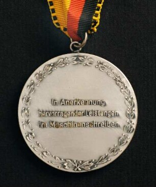 Silbermedaille Deutsche Meisterschaften in Kurzschrift und Maschinenschreiben in Schleswig 1985 am schwarz-rot-goldenen Band : Sammlung Deutscher Stenografenbund. Silbermedaille Deutsche Meisterschaften in Kurzschrift und Maschinenschreiben in Schleswig 1985 am schwarz-rot-goldenen Band. Messing, versilbert; Durchmesser 50 mm, Gewicht 51,5 g (1985; Deschler & Sohn, München). Dresden: SLUB R c 0540