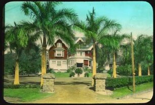 Honolulu (Hawaii). Anwesen mit Wohnhaus und Garten. Ansicht mit Heckeneinfriedung und Palmen
