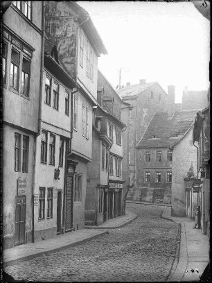 Blick aus der Kleinen Ulrichstraße gen Süden auf die Mündung der Kanzleigasse. linke Bildseite: Kleine Ulrichstraße 31 (Schild mit Handelsfrau Müller), Kleine Ulrichstraße 32 (Hasse, Bäckermeister), Kleine Ulrichstraße 33 (Schulze, Seilermeister), Dachritzstraße, Kleine Ulrichstraße 34, Kleine Ulrichstraße 35 (Schindler, Uhrmachermeister). Bildmitte: Kleine Ulrichstraße 2