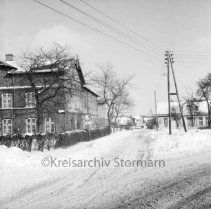 Rethwischdorf: Dorfplatz: Hauptstraße: Bundesstraße B 208 mit Kopfsteinpflaster: links Bauerngehöft Spiering: rechts Strommasten: dahinter Häuser: Winter