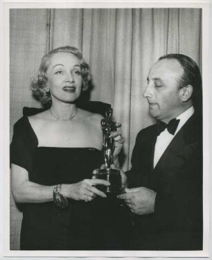 Marlene Dietrich überreicht dem Italienischen Konsul Dr. Mario Ungaro den Oscar für "Die Mauern von Malapaga" (mit Jean Gabin) als bestem fremdsprachigen Film (Los Angeles, März 1951) (Archivtitel)