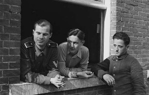 Zweiter Weltkrieg. Niederlande unter deutscher Besatzung. Drei deutsche Wehrmachtsangehörige an einem Fenster (wohl bei Den Haag)