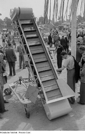 Ausstellungsbesucher an einem Förderband