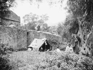 Zelt beim Kloster : Blick auf ein Zelt mit zwei Personen vor einer Klostermauer