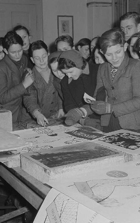 Schülerinnen und Schüler an der Hochschule für Grafik und Buchkunst beim Betrachten von Grafiken