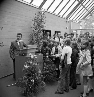 Schulzentrum Reinbek: Mühlenredder: Hauptschule [später: Hertzig-Schule, dann zusammen mit Realschule Reinbek Gemeinschaftsschule Reinbek]: Neubau: Einweihung: Innenansicht: Pausenhalle: Rede des Landesministers für Kultur Walter Braun, am Rednerpult zwischen Grünpflanzen: rechts Schüler, Lehrer und Gäste