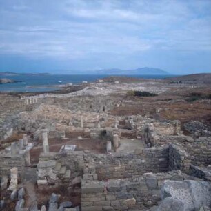 Delos. Delos, 3,5 km2. Blick aus dem römischen Wohnviertel auf Hafen und Agoren. Drüben Mykonos