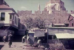 Reisefotos. Straßenbild mit Stadtmauer und Minarett?. Ansicht mit hölzerner Brücke an einem Kanal