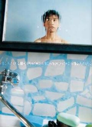 Junger Mann fotografiert sich vor einem Spiegel im Badezimmer (Sonderthema: Ein Bild von mir - Selbstporträts und Selbstdarstellungen)