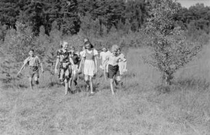 Ferienlager am Teufelssee : Kindergruppe über eine Wiese laufend