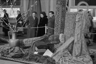 Messebesucher in der Ausstellungshalle der Sowjetunion vor einer Präsentation von Teppichen