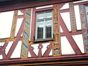 Stadtbild - Einhardshaus (1596) am Marktplatz aus Wolfstraße über Traufseite - Obergeschoß-Fachwerkstruktur und Ornamentik in Farbigkeit im Detail