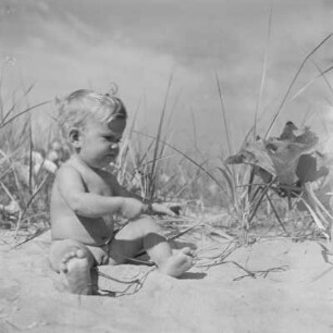 Kleinkind sitzt am Strand