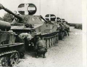 Soldaten der Nationalen Volksarmee beim Überprüfen von Panzerfahrzeugen
