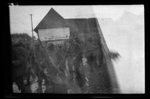 Metz-en-Couture (Dep. Pas-de-Calais, Frankreich): Soldatentrupp mit Stahlhelm auf einer morastigen Ortsstraße