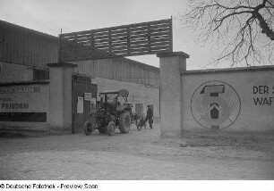 Traktor mit Pflug vor dem Eingangstor