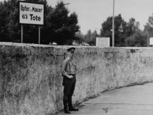 Blick über die Staatsgrenze zu Westberlin/Berliner Mauer am Brandenburger Tor, auf Westberliner Seite ein Schild "Opfer der Mauer - 63 Tote"