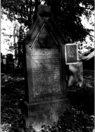 Grabstein 381 (Index: 100111859) Material: Sandstein Zustand: leicht verwittert Maße HxBxT: 153x55x20 cm Beschreibung: Stele, getreppter Sockel, eingezogener giebelartiger Abschluß, rechteckig erhöht, Schriftfeld eingetieft Symbolik: segnende Hände: Grabstein 381