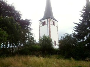 Ansicht von Südwesten mit Kirchturm (Romanisch 13 Jh) in ehemaligem Kirchhof in erhöhter Lage über dem Ort