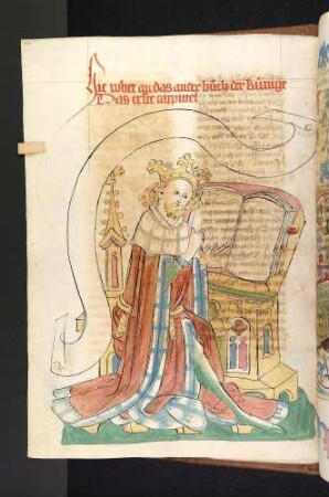 König am Pult deutet auf ein Buch