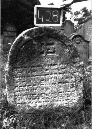 Grabstein 428 (Index: 100102766) Material: Sandstein Zustand: stark verwittert, eingesunken, unten Textverlust Maße HxBxT: 104x77x13 cm Beschreibung: Stele, eingezogener Rundbogenabschluss, Schriftfeld eingetieft: Grabstein 428