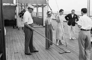 Bordleben Cap Arcona. Passagiere auf dem Oberdeck während eines Shuffleboard-Spiels