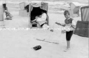 Junge am Strand mit Spielzeug-Panzer