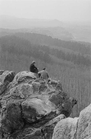 Blick in die Harzlandschaft, im Vordergrund zwei Personen auf einem Felsen