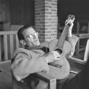 Mann mit Brille spielt Gitarre