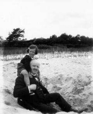 Mann mit Kind am Strand