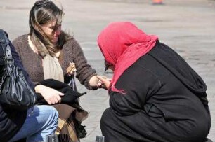 Auf dem Platz Djemaa el-Fna : Eine marokkanische Frau (rechts) bringt einer Touristin ein Hennatattoo auf die Hand, aufgenommen am 02.11.2008