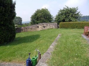 Kirchhof im Norden nach Westen mit Kirchhofmauer (Wehrgang mit Steinbrüstung und Schießscharten abgetragen) und einigen erhaltenen Konsolsteinen des einstigen Wehrgangs