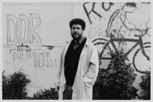 Der Lyriker und Übersetzer Richard Pietraß vor einer Graffiitiwand