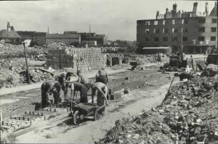 Hamburg-Altona, Koldingstraße 2, kurz vor der Ecke Düppelstraße in nordöstlicher Blickrichtung, links im Bild die Kirche der Mennoitengemeinde an der Langenfelder Straße 100/102. Das Gebäude rechts im Bild ist die Düppelstraße 17, rechts geht es in die Gefionstraße. Wohnungsaufbau, Arbeiter stellen Ziegel aus Trümmersplitt her