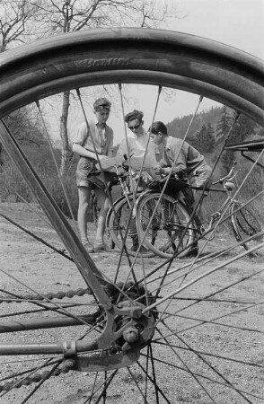Drei junge Radfahrer studieren die Landkarte, im Vordergrund ein Rad des Reifenherstellers Barum