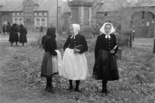 Frauen in Schleifer Kirchgangstracht in Schleife. : Žony w Slepjanskej kemšacej drasće w Slepom.