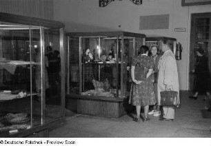 Besucher der Herbstmesse 1953 stehen vor Ausstellungsvitrinen mit diversen kunsthandwerklichen Gegenständen