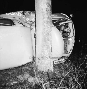 B 75: bei Steinfeld: Verkehrsunfall: Kleintransporter prallt gegen Baum: Unfallwagen einer Reinigung aus Bad Oldesloe in Seitenlage, mit Dach an Baum, Blick auf Fahrerkabine: im Dunkeln
