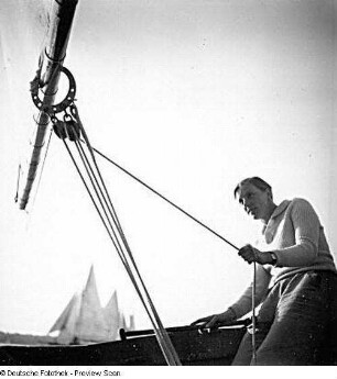 Segellehrerin auf einem Segelboot ein Segel bedienend