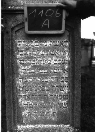 Grabstein 1106 (Index: 100104175) Material: Muschelkalk Zustand: gut erhalten Maße HxBxT: 193x51x20 cm Beschreibung: aufgesockelte Stele mit unten mehrfach profiliertem Giebelaufsatz, Aufsatz mit Voluten und stilisiertem Akanthus, Schriftfeld eingetieft, mit Segmentbogenabschluss, deutsche Inschrift durch rechteckige Rahmenlinie gerahmt Symbolik: Voluten, Akanthus: Grabstein 1106A