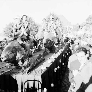 Karpfenfest: Umzug: Festwagen, Fischerinnen reiten auf mehreren Riesenkarpfen: umgeben von Zuschauern, 11. Oktober 1959