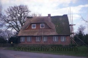 Backsteinhaus mit Reetdach: ehemalige Schule: Renovierung: traufständige Straßenfront mit breiter Gaube: an Giebelfront Gerüst