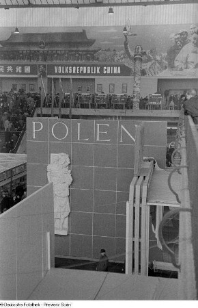 Innenansicht einer Messehalle mit einem Treppenaufgang zur Ausstellungsfläche der Volksrepublik China, unten die Ausstellungsfläche Polens