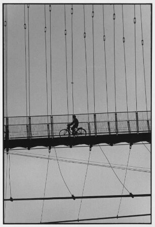 Rishikesh. Fahrradfahrer auf der Lakshman Jula Brücke über dem Ganges