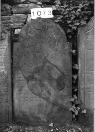 Grabstein 1073 (Index: 99630576) Material: Sandstein Zustand: völlig abgeblättert Maße HxBxT: 111x60x8 cm Beschreibung: Stele mit eingezogenem Rundbogenabschluß: Grabstein 1073