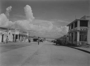 Straßenszene : Häuserzeile entlang einer unbefestigten Straße in Namibia? Im Hintergrund der Atlantik